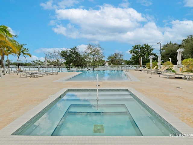 view of swimming pool with a community hot tub and a patio area