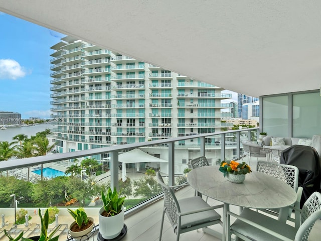 balcony featuring a city view and a water view