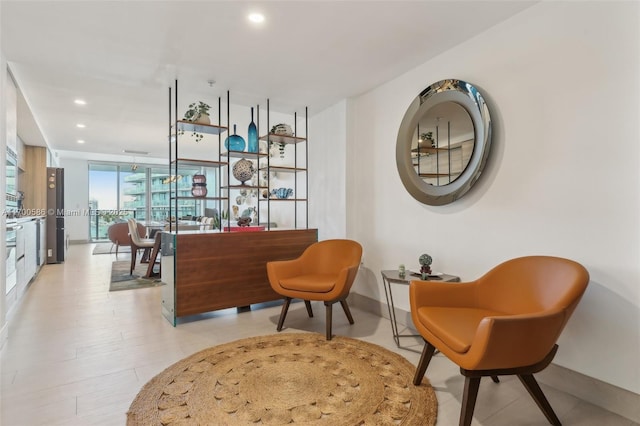 sitting room with baseboards, a wall of windows, and recessed lighting