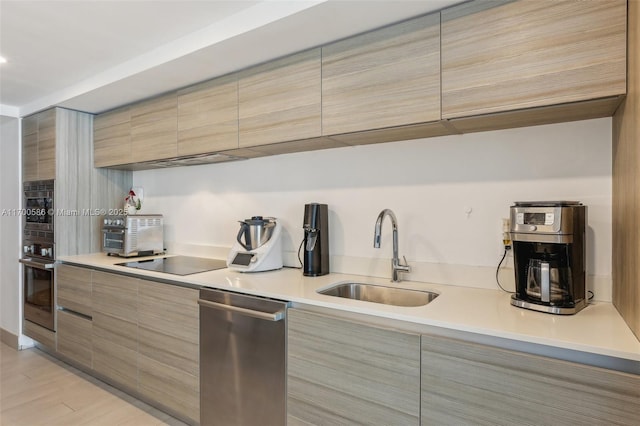 kitchen with sink, light wood-type flooring, and appliances with stainless steel finishes