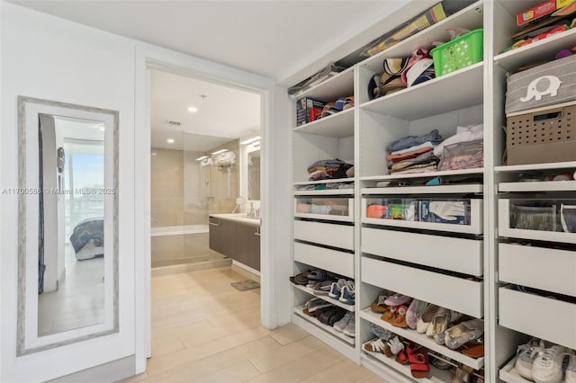 walk in closet with light wood-style flooring