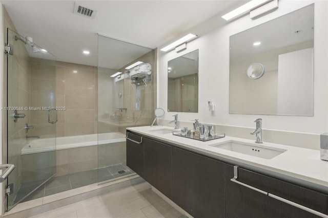 bathroom with tiled shower / bath combo, a sink, visible vents, and tile patterned floors