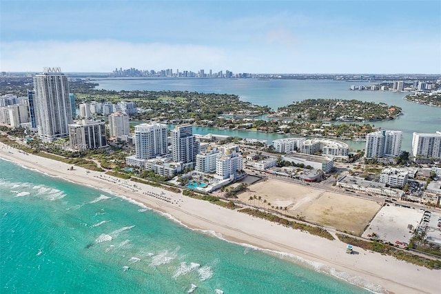 aerial view with a city view, a water view, and a beach view