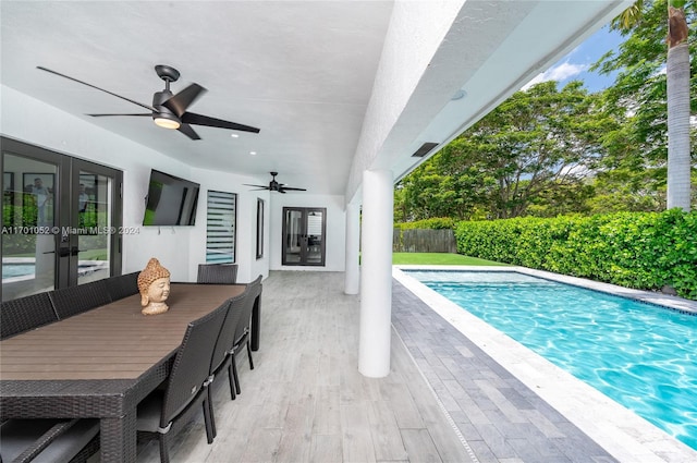 view of swimming pool featuring ceiling fan and french doors