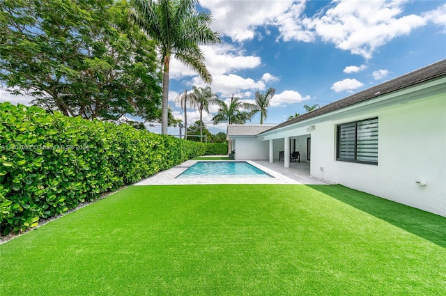 view of pool with a lawn and a patio