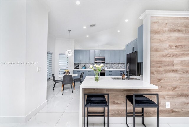 kitchen with a kitchen bar, kitchen peninsula, tasteful backsplash, stainless steel appliances, and sink