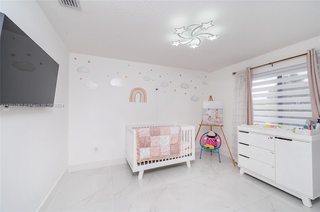 bedroom with a textured ceiling and a crib