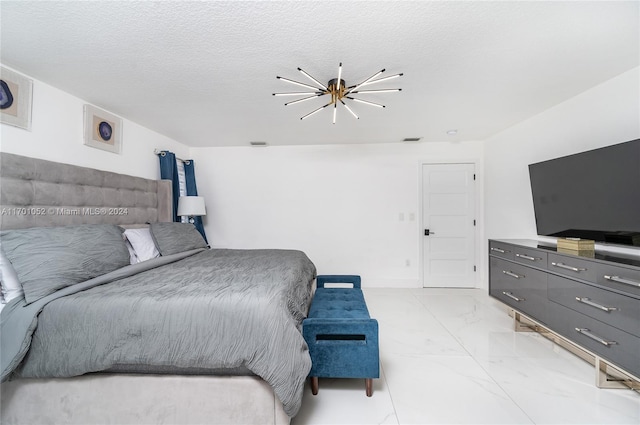 bedroom with a chandelier and a textured ceiling