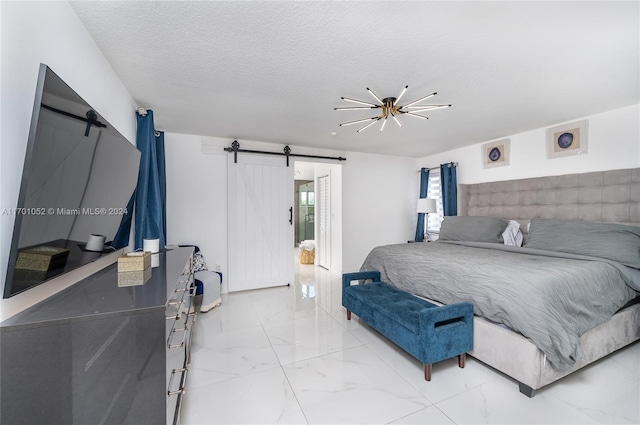 bedroom with a barn door, ceiling fan, and a textured ceiling