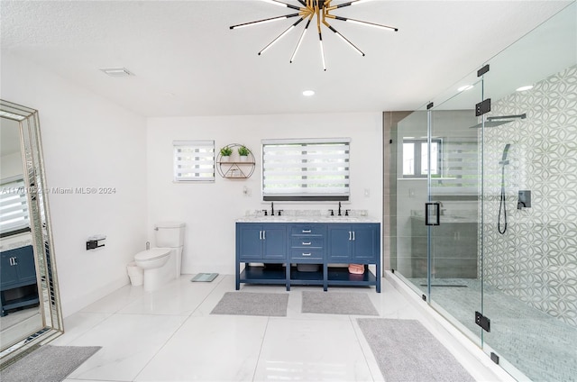 bathroom featuring tile patterned floors, vanity, a shower with door, a chandelier, and toilet