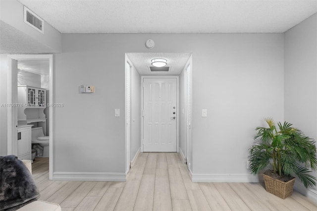 foyer featuring a textured ceiling and light hardwood / wood-style flooring