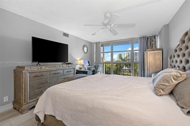 bedroom featuring a textured ceiling, ceiling fan, and light hardwood / wood-style flooring