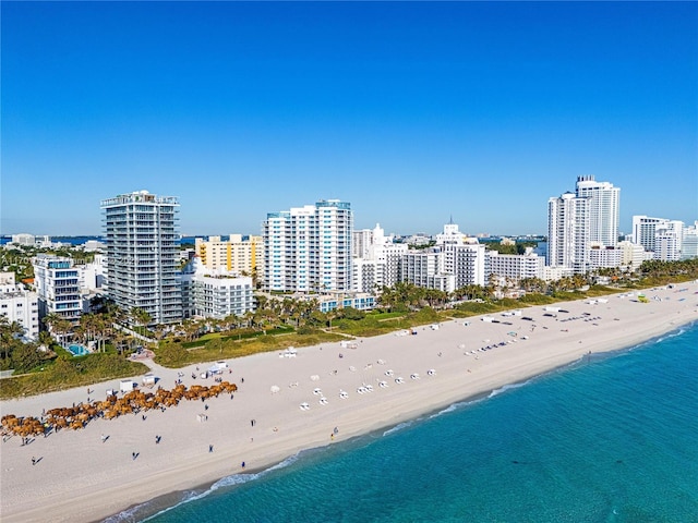 bird's eye view featuring a water view and a beach view