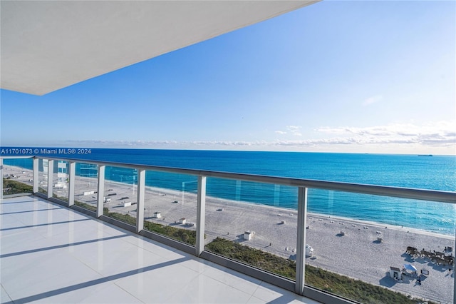 balcony featuring a water view and a beach view