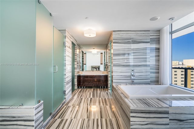 bathroom featuring separate shower and tub, a wealth of natural light, and vanity