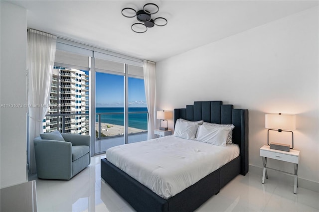 tiled bedroom featuring access to exterior, a water view, and a wall of windows