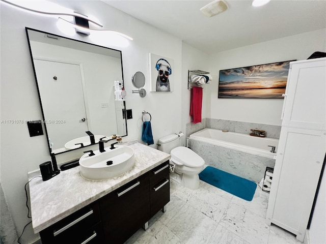 bathroom with tiled tub, vanity, and toilet