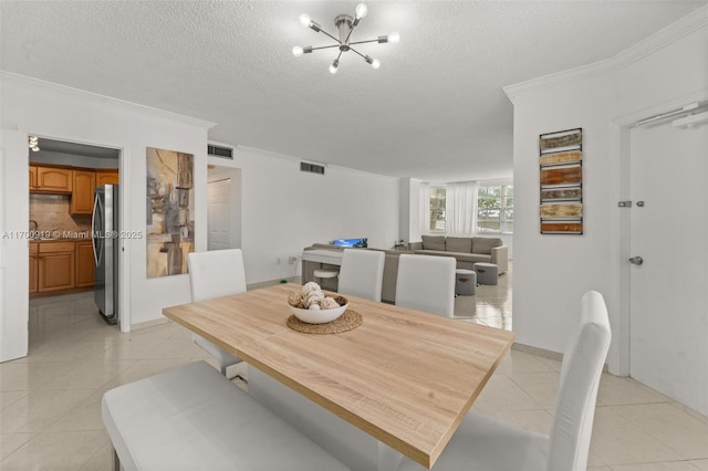 tiled dining room with a notable chandelier, crown molding, and a textured ceiling