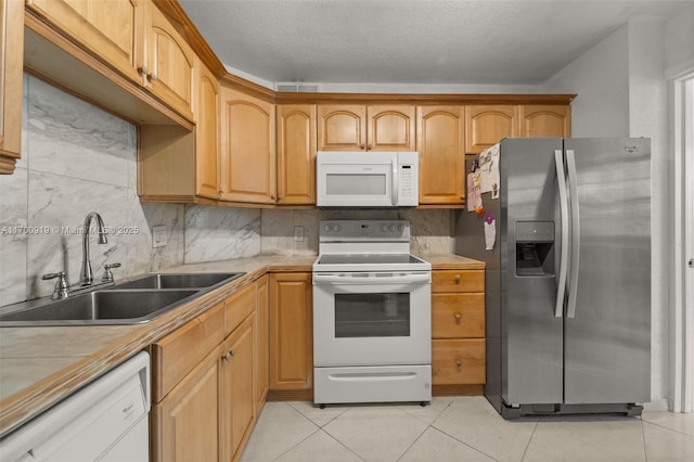 kitchen featuring sink, white appliances, decorative backsplash, and light tile patterned flooring