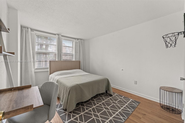 bedroom featuring wood-type flooring and a textured ceiling