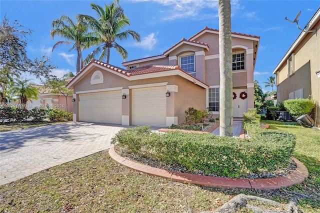 mediterranean / spanish-style home featuring central AC unit and a garage