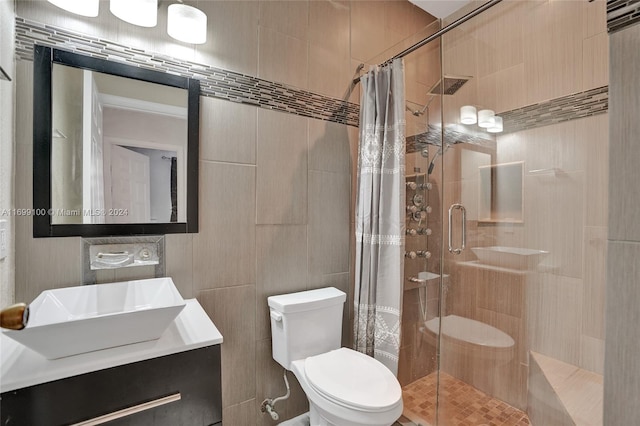 bathroom with a shower with curtain, vanity, toilet, and tile walls