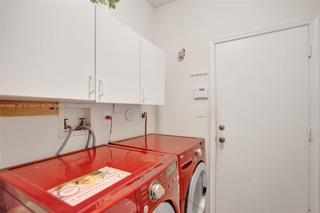 laundry room with washing machine and clothes dryer and cabinets