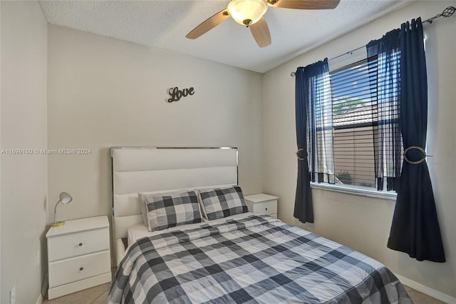 bedroom with ceiling fan and a textured ceiling