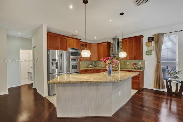 kitchen featuring stainless steel refrigerator with ice dispenser, dark hardwood / wood-style floors, a center island with sink, and wall chimney range hood