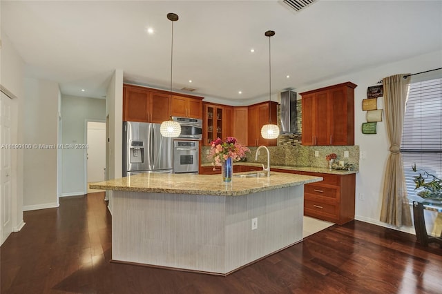 kitchen featuring light stone countertops, stainless steel refrigerator with ice dispenser, wall chimney exhaust hood, a kitchen island with sink, and dark wood-type flooring