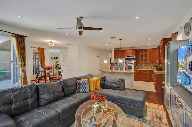 living room with dark hardwood / wood-style flooring and ceiling fan