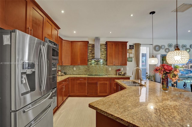 kitchen with pendant lighting, wall chimney range hood, sink, tasteful backsplash, and stainless steel appliances