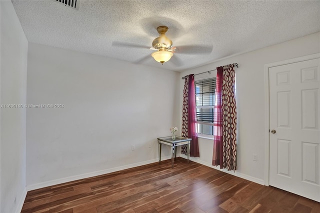 spare room featuring ceiling fan, dark hardwood / wood-style flooring, and a textured ceiling