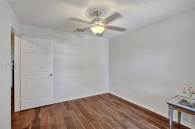 spare room featuring wood-type flooring, a textured ceiling, and ceiling fan