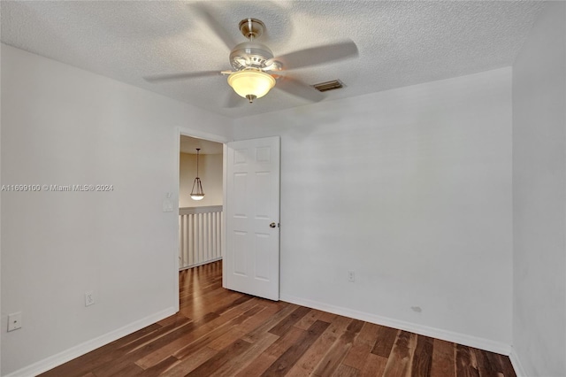 unfurnished room with a textured ceiling, dark hardwood / wood-style flooring, and ceiling fan