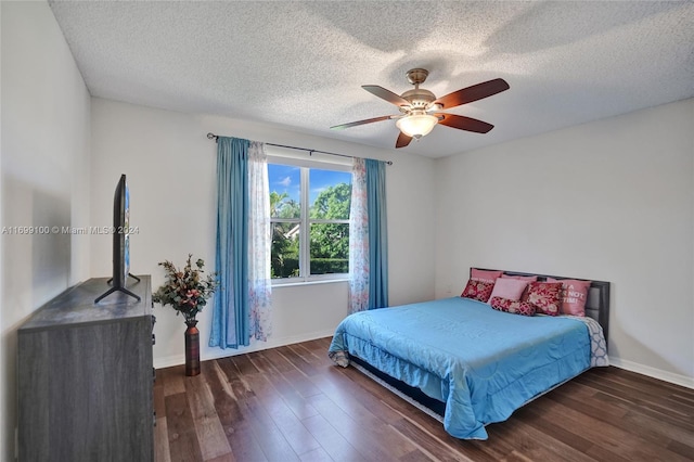 bedroom with ceiling fan, dark wood-type flooring, and a textured ceiling