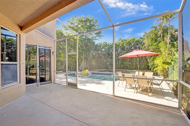 unfurnished sunroom featuring lofted ceiling with beams