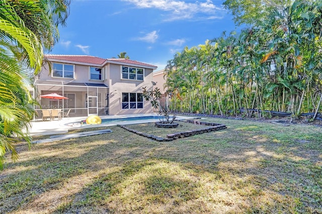 back of house with a yard and a patio