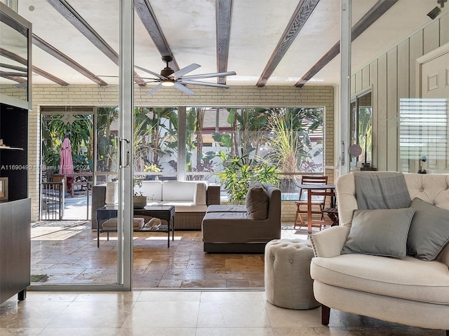 sunroom / solarium with beamed ceiling, plenty of natural light, and ceiling fan