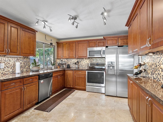 kitchen featuring a textured ceiling, sink, track lighting, and appliances with stainless steel finishes