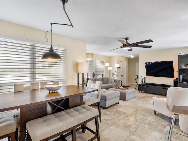 living room with ceiling fan and a textured ceiling