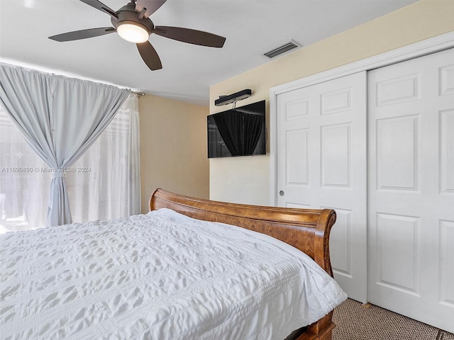 bedroom with ceiling fan, carpet floors, and a closet