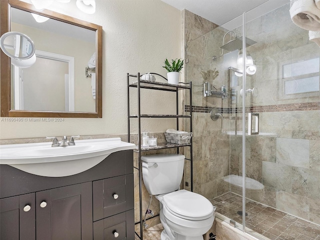 bathroom with a shower with door, vanity, and toilet