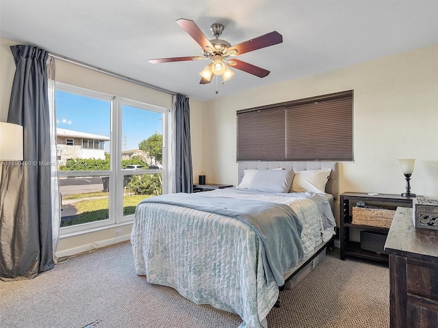 carpeted bedroom with ceiling fan and multiple windows