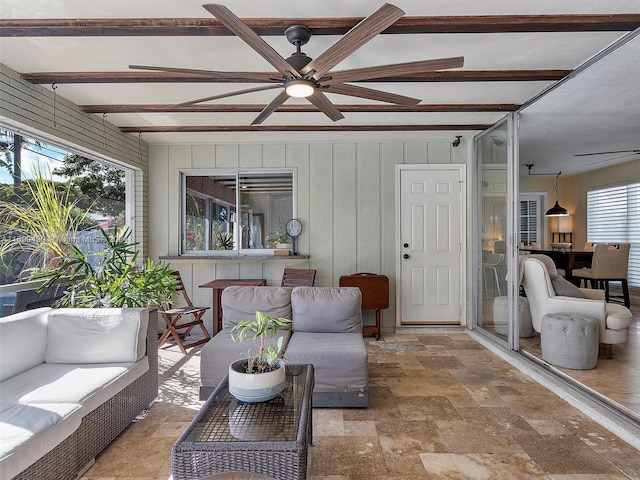 sunroom / solarium featuring ceiling fan, beam ceiling, and a wealth of natural light