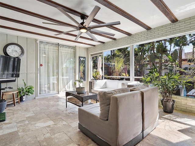 sunroom featuring beam ceiling and ceiling fan