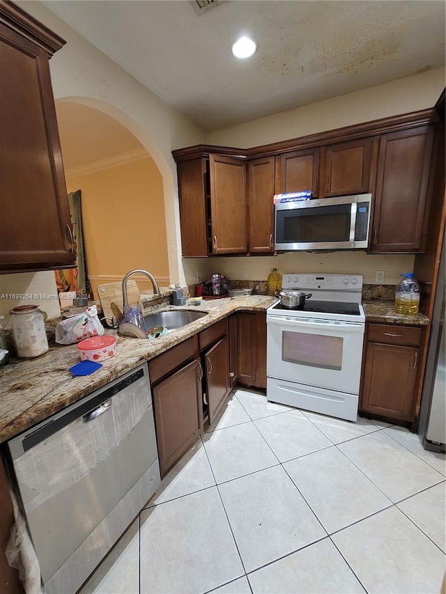 kitchen featuring crown molding, sink, light stone counters, and stainless steel appliances