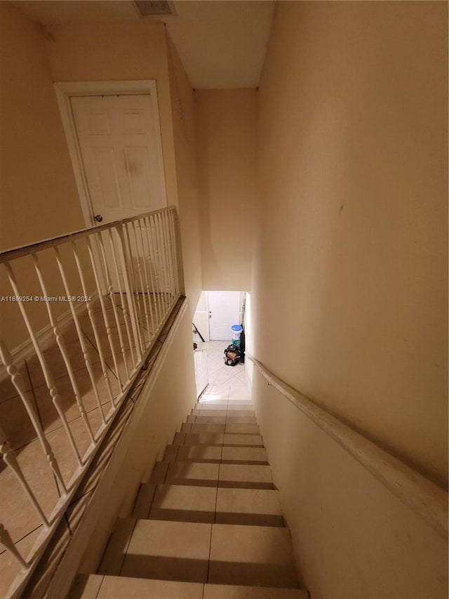 staircase featuring tile patterned floors