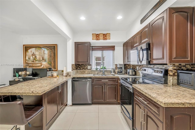 kitchen featuring kitchen peninsula, stainless steel appliances, tasteful backsplash, and sink