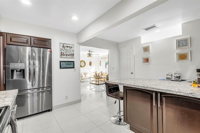 kitchen with dark brown cabinetry, ceiling fan, stainless steel appliances, beamed ceiling, and light tile patterned floors